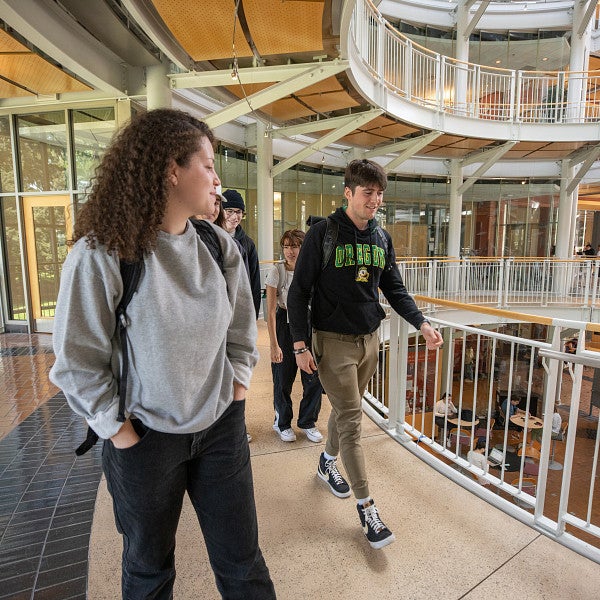 Group of students walking on the second floor of the Lillis Business Complex