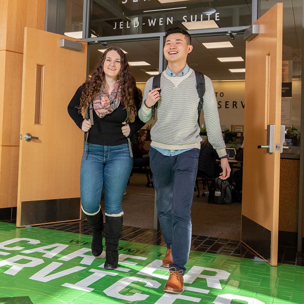 Two students walking out of Mohr Career Services in the Lillis Business Complex.